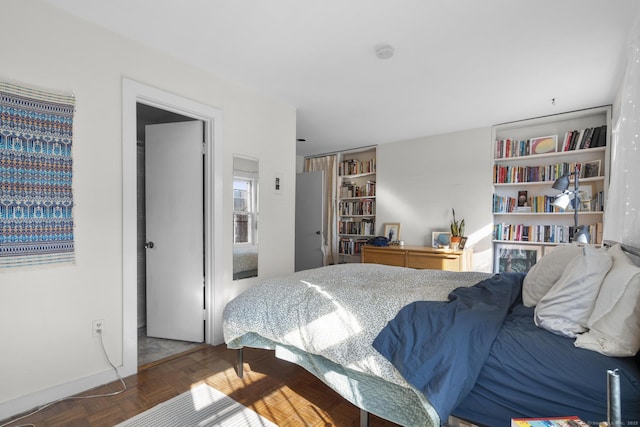 bedroom featuring dark parquet flooring