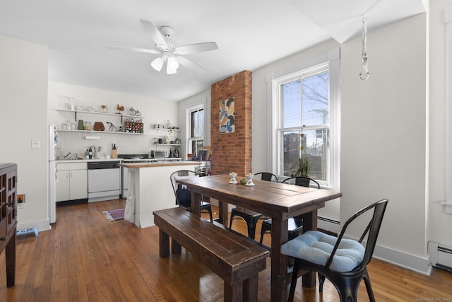 dining area with dark wood-type flooring, ceiling fan, and a baseboard heating unit