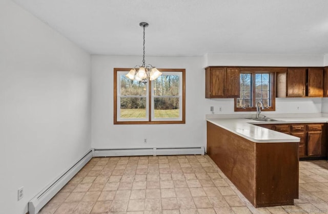 kitchen with sink, pendant lighting, baseboard heating, and kitchen peninsula