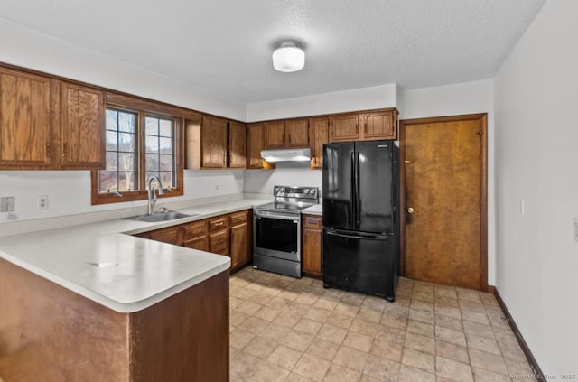 kitchen featuring sink, black refrigerator, stainless steel range with electric stovetop, a textured ceiling, and kitchen peninsula