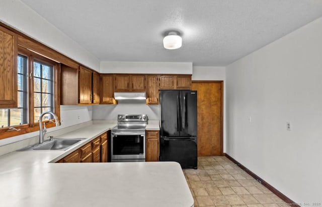 kitchen featuring sink, stainless steel electric range oven, a textured ceiling, and black fridge