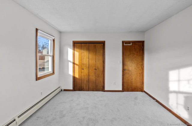 unfurnished bedroom with a baseboard radiator, light carpet, and a closet