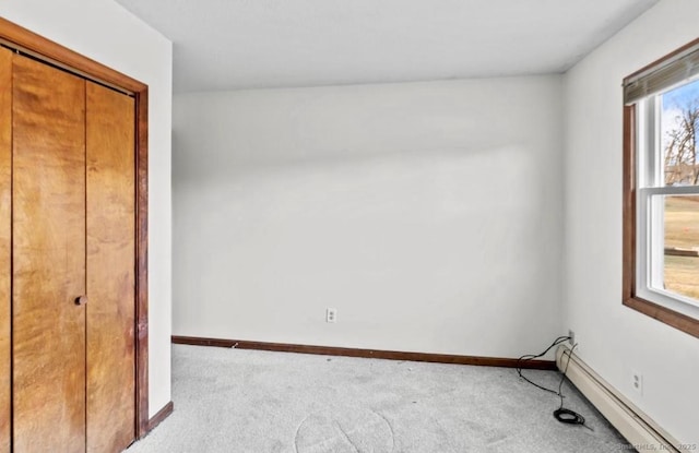 unfurnished bedroom with baseboard heating and light colored carpet