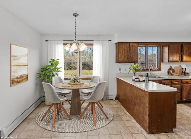 dining space with a baseboard radiator, sink, and a notable chandelier