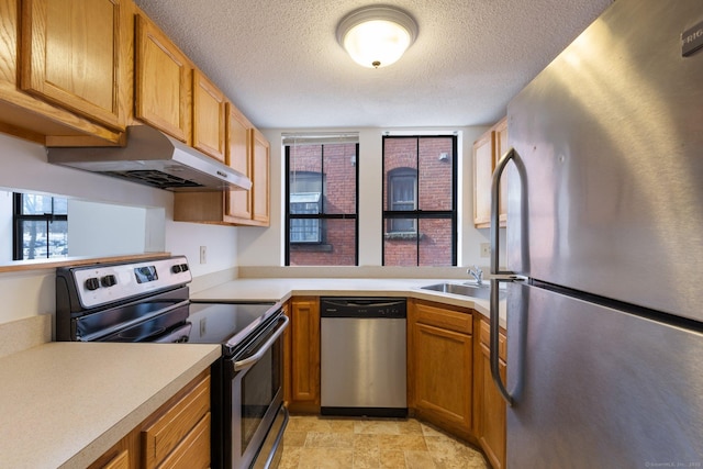 kitchen featuring appliances with stainless steel finishes, sink, and a textured ceiling