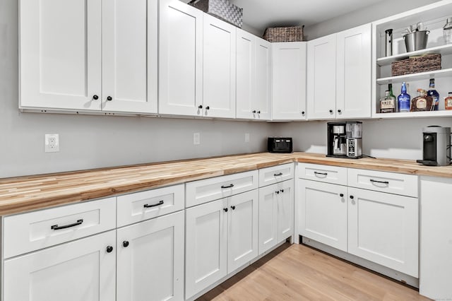 kitchen featuring white cabinetry, butcher block counters, and light hardwood / wood-style flooring