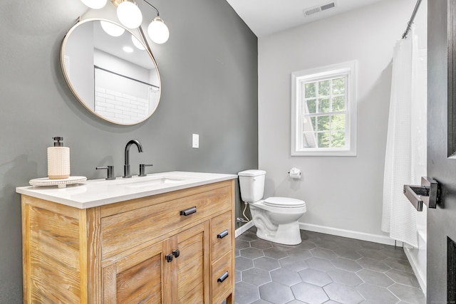 bathroom featuring vanity, a shower with shower curtain, tile patterned floors, and toilet