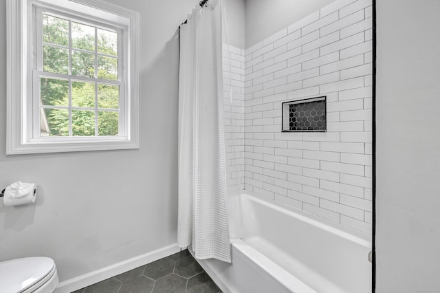 bathroom featuring toilet, tile patterned floors, and shower / bath combo with shower curtain