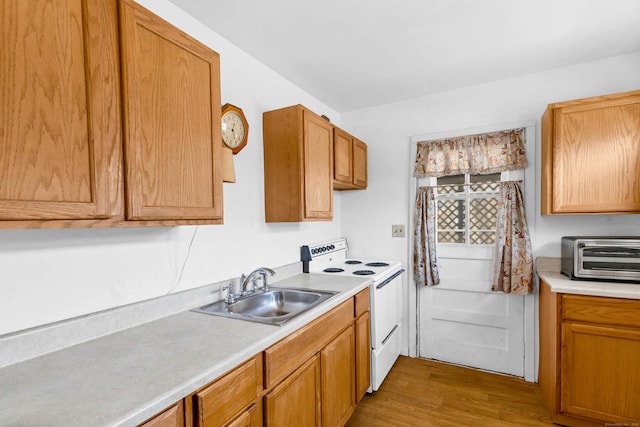 kitchen featuring electric stove, a toaster, light countertops, a sink, and wood finished floors