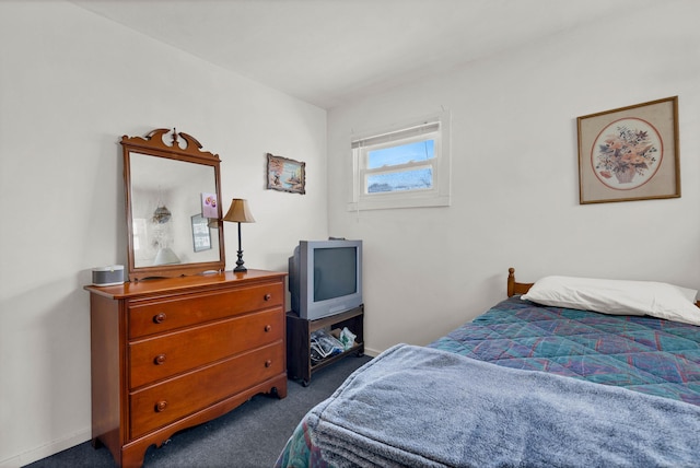 bedroom featuring dark carpet and baseboards