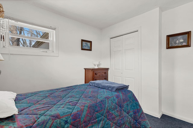 carpeted bedroom with a closet and baseboards