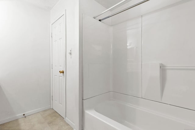 bathroom with shower / tub combination and baseboards