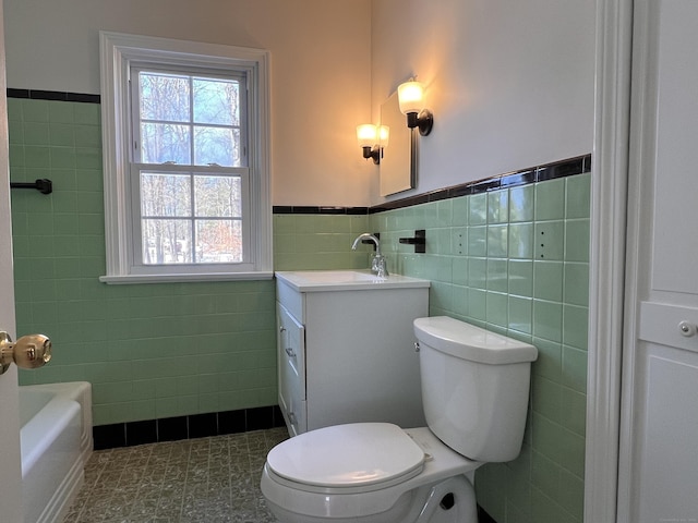 bathroom with vanity, tile patterned flooring, tile walls, and toilet