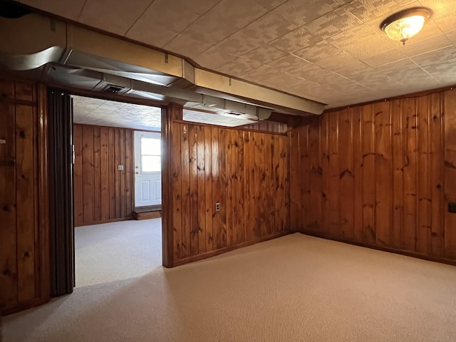 basement featuring wooden walls and light carpet