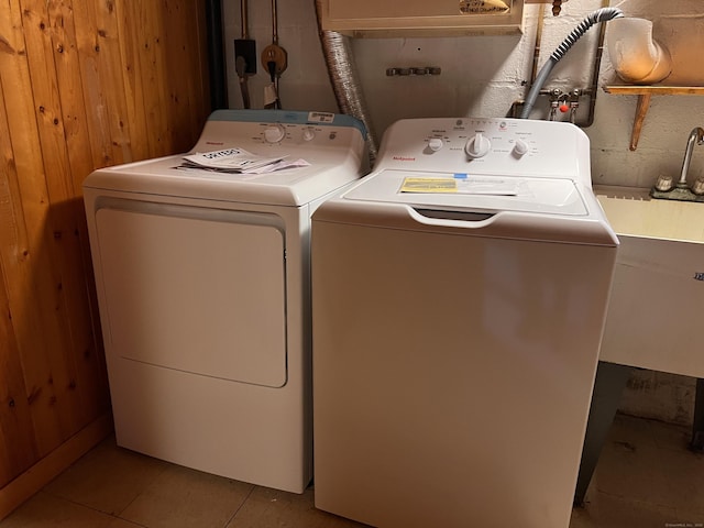 washroom with wooden walls, light tile patterned floors, and independent washer and dryer