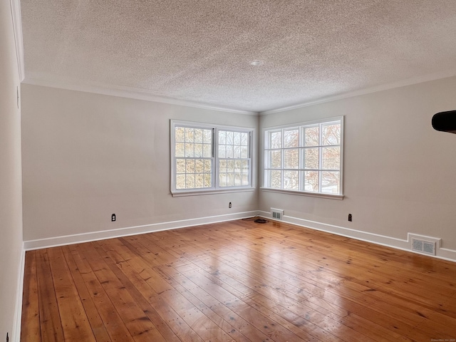 empty room with crown molding, wood-type flooring, and a textured ceiling