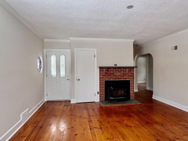 entryway with crown molding, a fireplace, hardwood / wood-style floors, and a textured ceiling