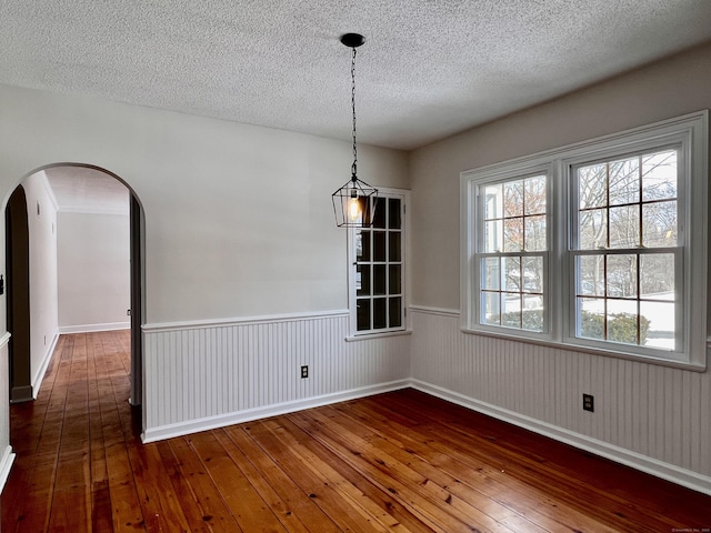 unfurnished dining area with dark hardwood / wood-style floors and a textured ceiling