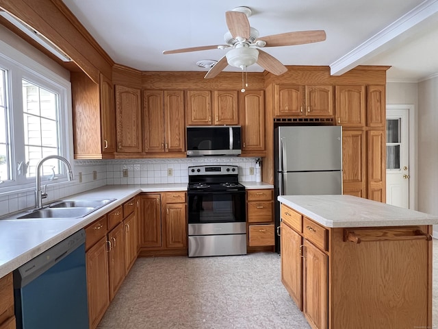 kitchen featuring sink, appliances with stainless steel finishes, ornamental molding, a kitchen island, and decorative backsplash