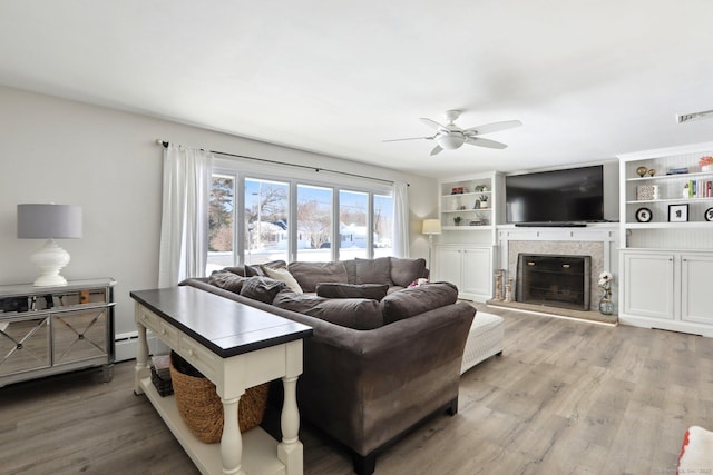 living room with baseboard heating, ceiling fan, a fireplace, and hardwood / wood-style floors