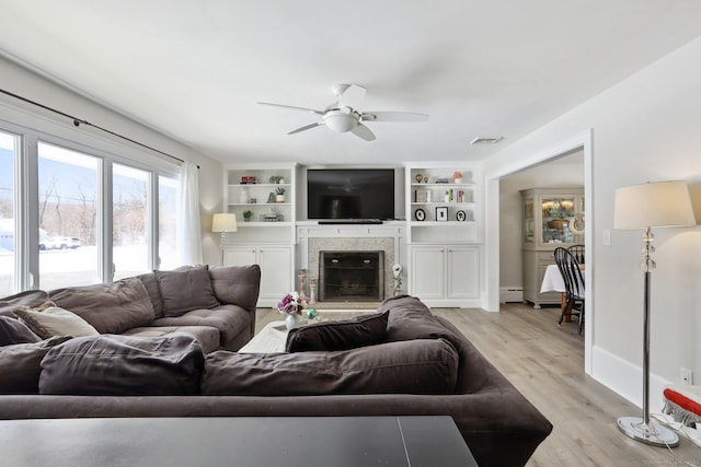 living room with ceiling fan, light hardwood / wood-style floors, and baseboard heating