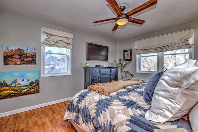 bedroom with multiple windows, light hardwood / wood-style flooring, and ceiling fan