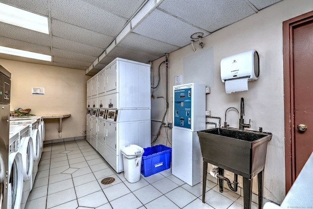 washroom featuring stacked washer / dryer, sink, washing machine and dryer, and light tile patterned floors