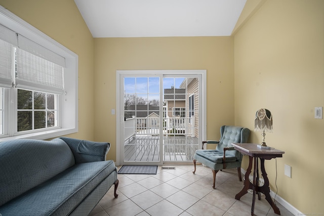 sitting room with lofted ceiling and light tile patterned floors