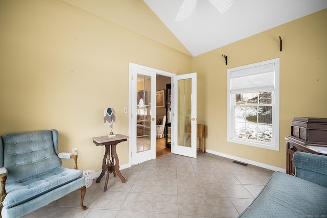 sitting room featuring lofted ceiling, light tile patterned floors, and french doors