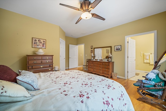 bedroom featuring ensuite bath, light hardwood / wood-style floors, and ceiling fan