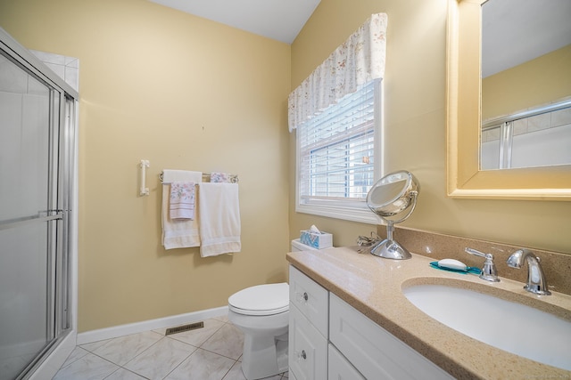 bathroom with tile patterned flooring, vanity, a shower with door, and toilet