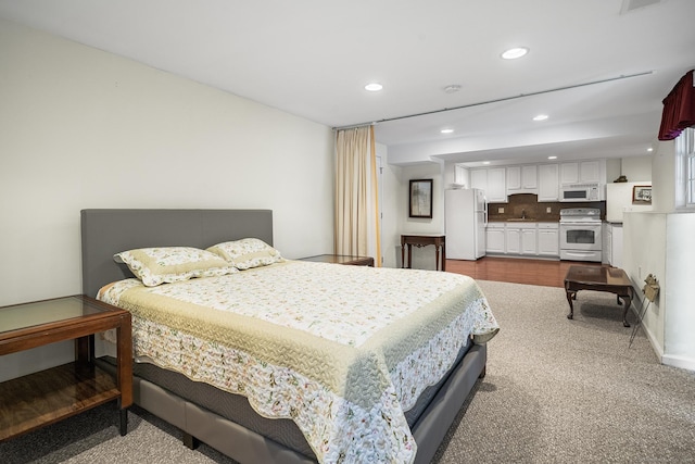 bedroom featuring sink and white fridge