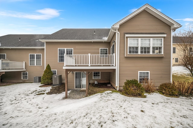 snow covered property featuring a balcony and central AC unit