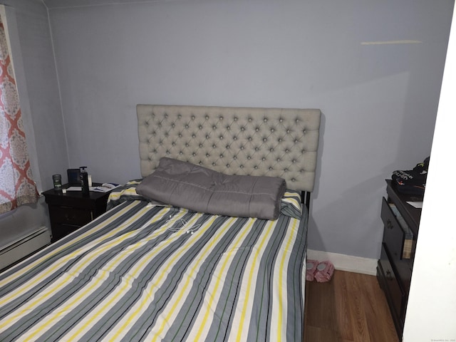 bedroom featuring dark wood-type flooring and baseboard heating