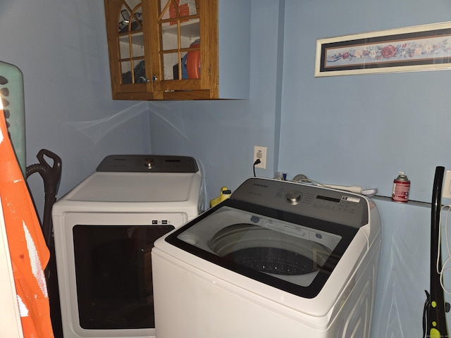 washroom featuring cabinets and independent washer and dryer