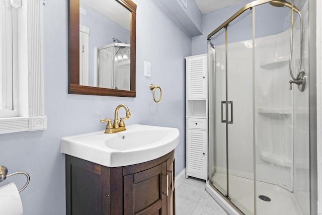 bathroom featuring a shower with door and vanity