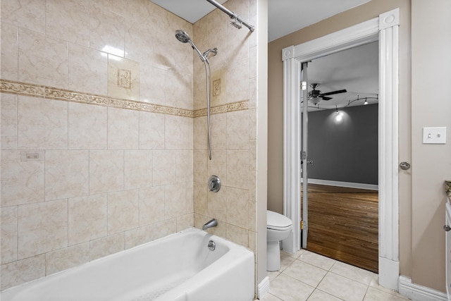 bathroom with ceiling fan, tiled shower / bath combo, tile patterned floors, and toilet