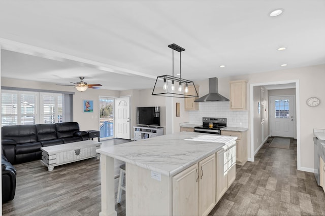 kitchen featuring wall chimney exhaust hood, stainless steel range with electric cooktop, a kitchen island, pendant lighting, and backsplash