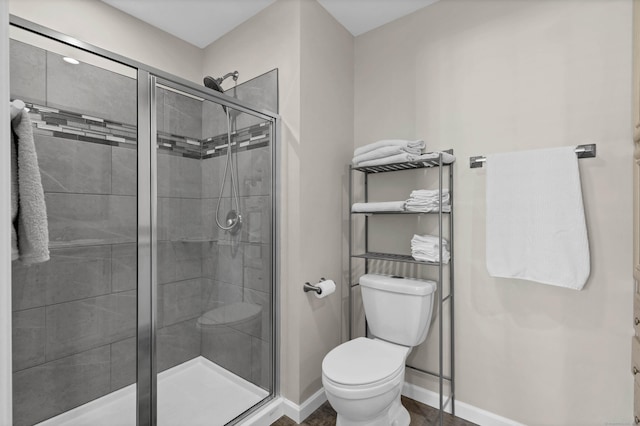 bathroom with toilet and an enclosed shower