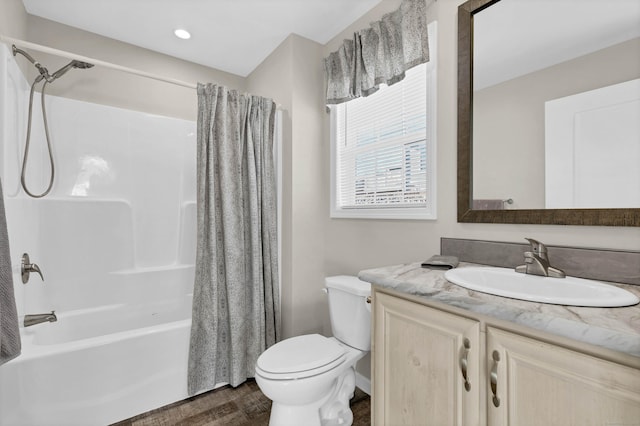 full bathroom with hardwood / wood-style flooring, vanity, toilet, and shower / bath combo with shower curtain