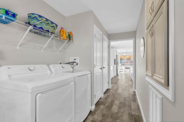 laundry area featuring separate washer and dryer, dark wood-type flooring, and a chandelier