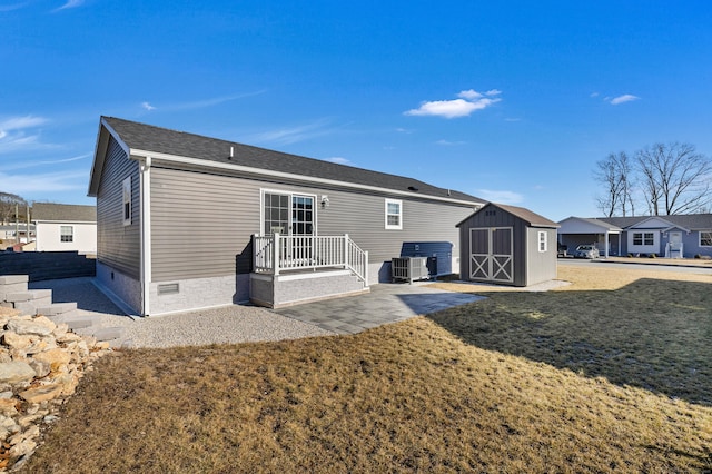 back of property with central AC, a patio, a lawn, and a shed