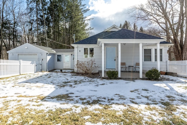 bungalow-style house featuring a garage, an outdoor structure, and a porch