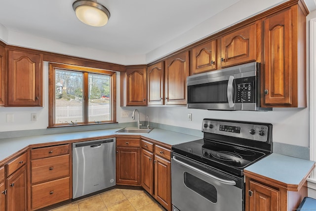 kitchen featuring stainless steel appliances, sink, and light tile patterned floors