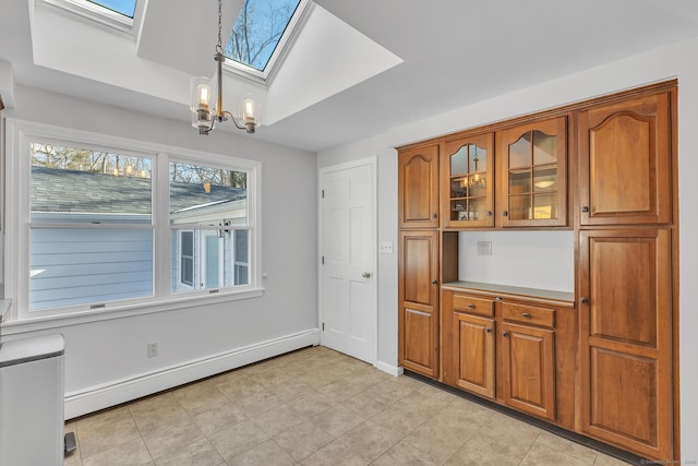 kitchen with a baseboard radiator, pendant lighting, a notable chandelier, and a skylight