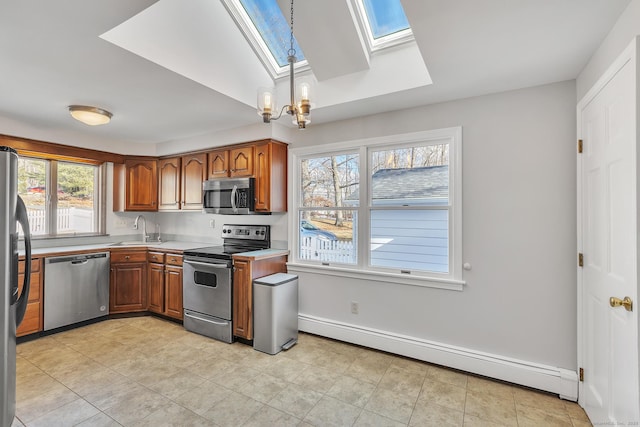 kitchen with a skylight, sink, a baseboard heating unit, stainless steel appliances, and an inviting chandelier