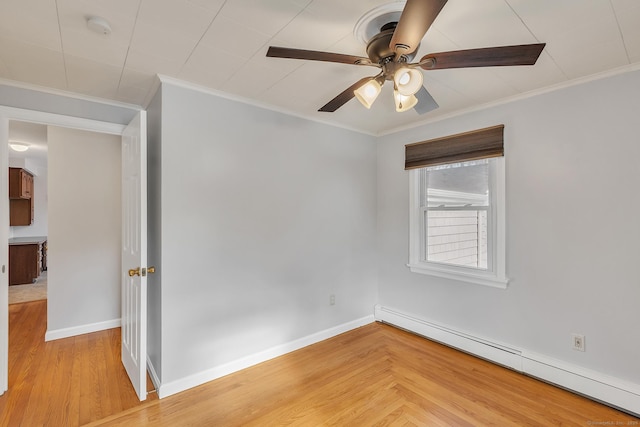 spare room with baseboard heating, ceiling fan, ornamental molding, and light hardwood / wood-style floors