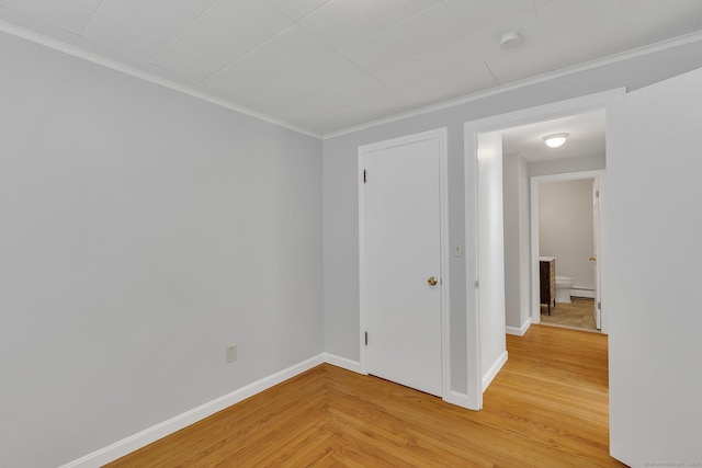 empty room featuring wood-type flooring, ornamental molding, and a baseboard radiator