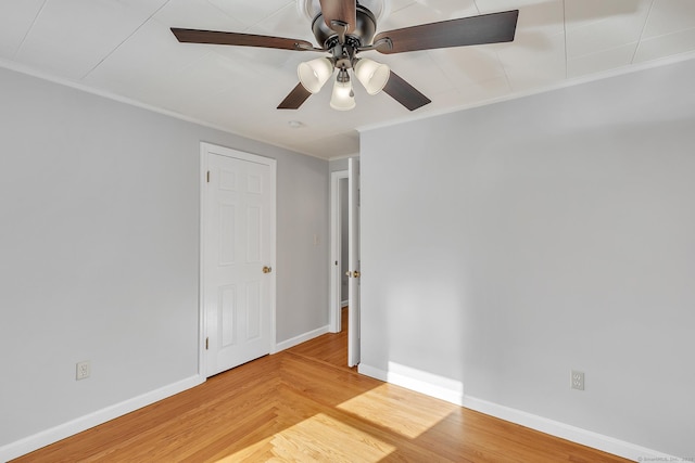 empty room featuring hardwood / wood-style floors, ornamental molding, and ceiling fan