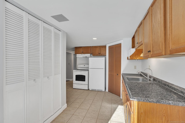 kitchen with white appliances, sink, and light tile patterned floors